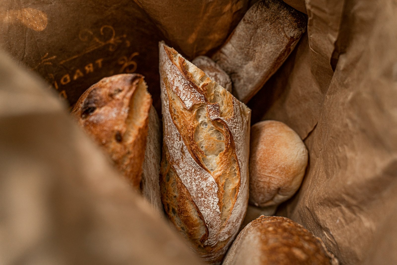 Fresh artisan bread nestled in a brown paper bag
